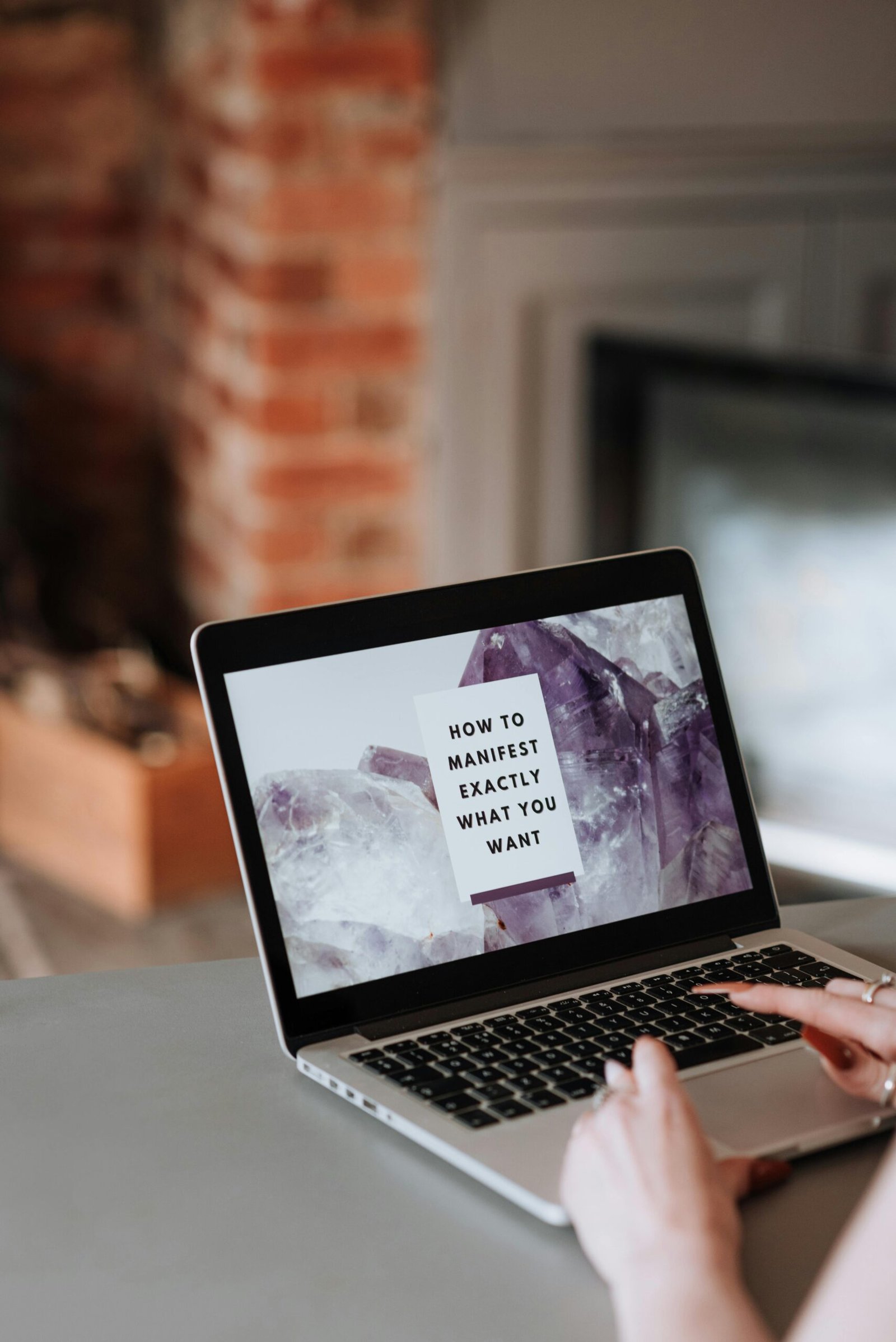 Crop anonymous female using netbook with creative desktop and motivation how to manifest exactly what you want